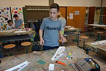 Ein Junge beim Kleben von Modellfluzeugteilen.