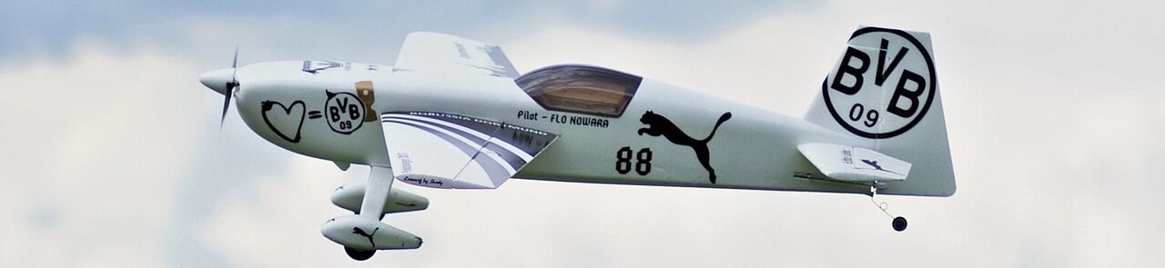 Kunstflugmodellflugzeug im BVB Design vor den Wolken