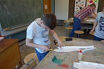 Ein Jugendlicher der Modellbau AG beim schneiden von Einzelteilen.