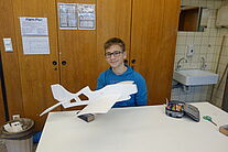 Schüler hält seinen Modellflugzeug Rohbau in der Hand