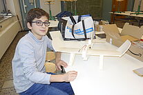 Schüler und sein Modellflugzeug Rohbau