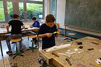 Schüler beim bauen eines Modellflugzeug.
