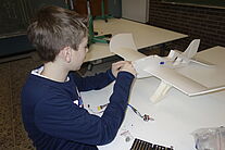 Schüler beim Einbau des Elektromotors an seinem Modell