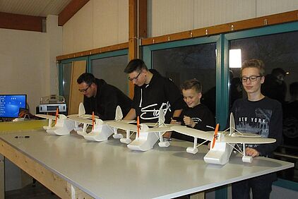 Jugendliche beim Modellbau Workshop bauen ein Modellflugzeug
