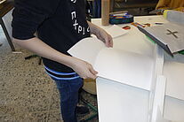 Schüler hält den Flügel in der Hand